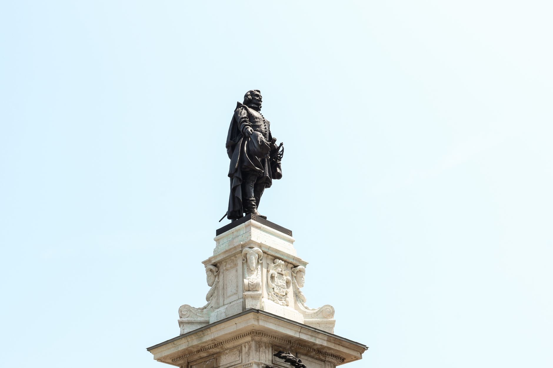 Iconic statue of Samuel de Champlain overlooking Québec City on a bright day.