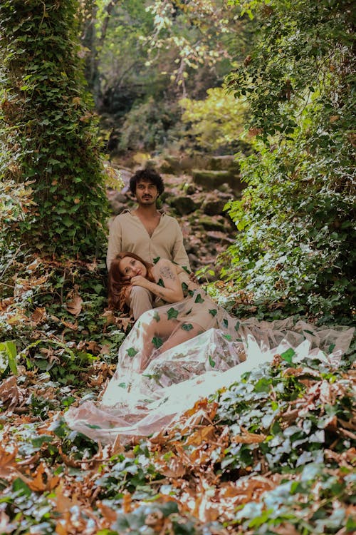 Model in Long Dress Posing With Man in Garden