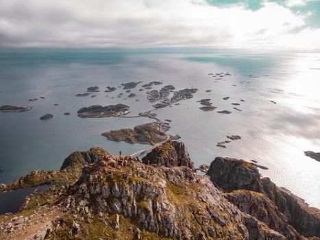Stunning aerial view of Henningsvær's scenic islands, rocky terrain, and ocean during day.