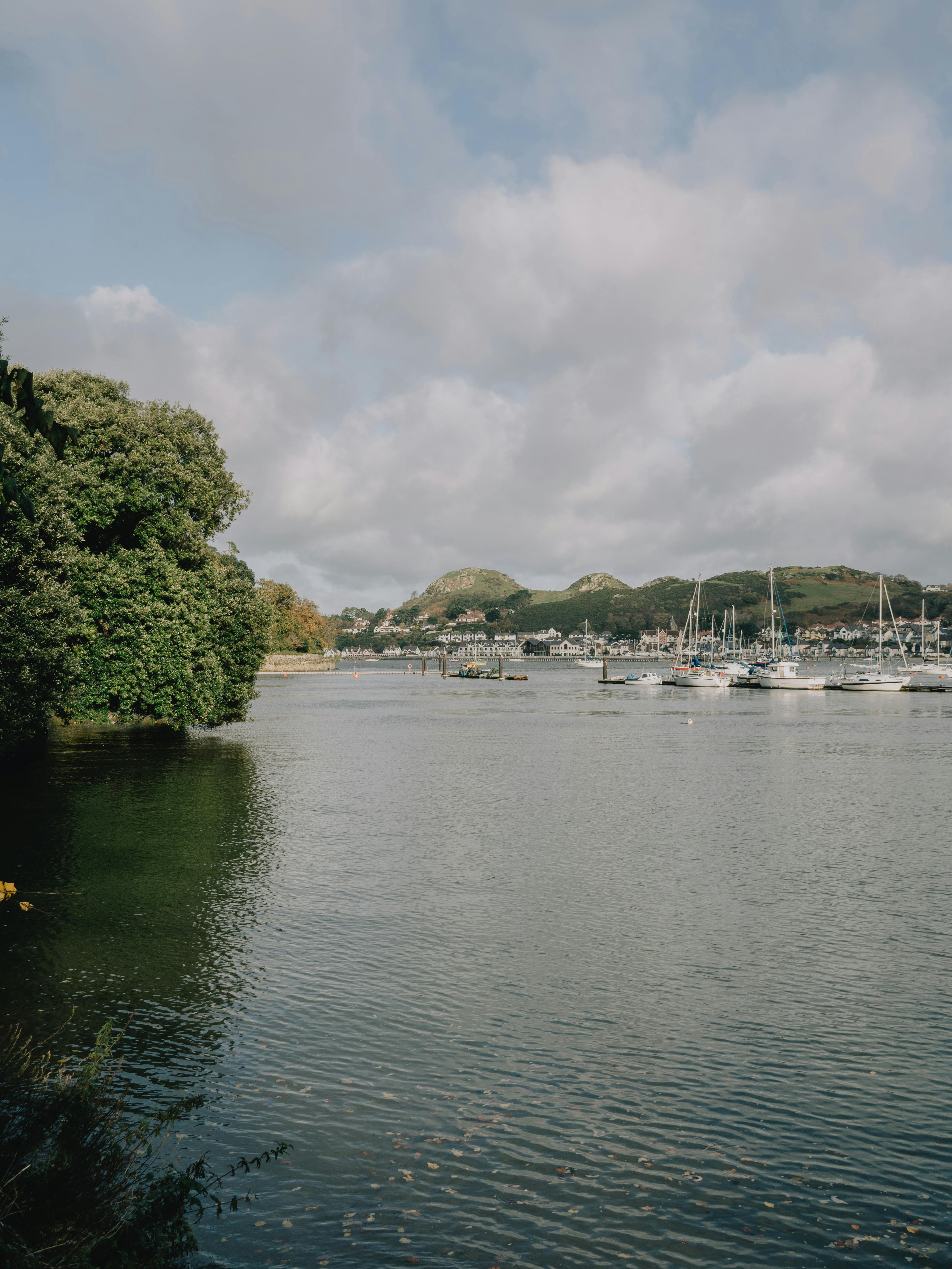Boats peacefully moored in Conwy Marina, Wales, under cloudy skies.