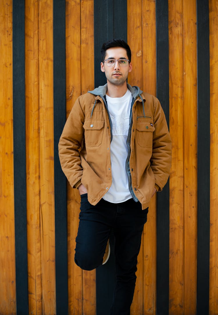 Young Man In A Beige Jacket Standing With His Hands In Pockets 