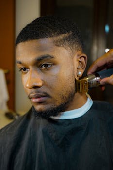 A man getting a precise beard trim at a barber shop, showcasing meticulous grooming and hairstyle.