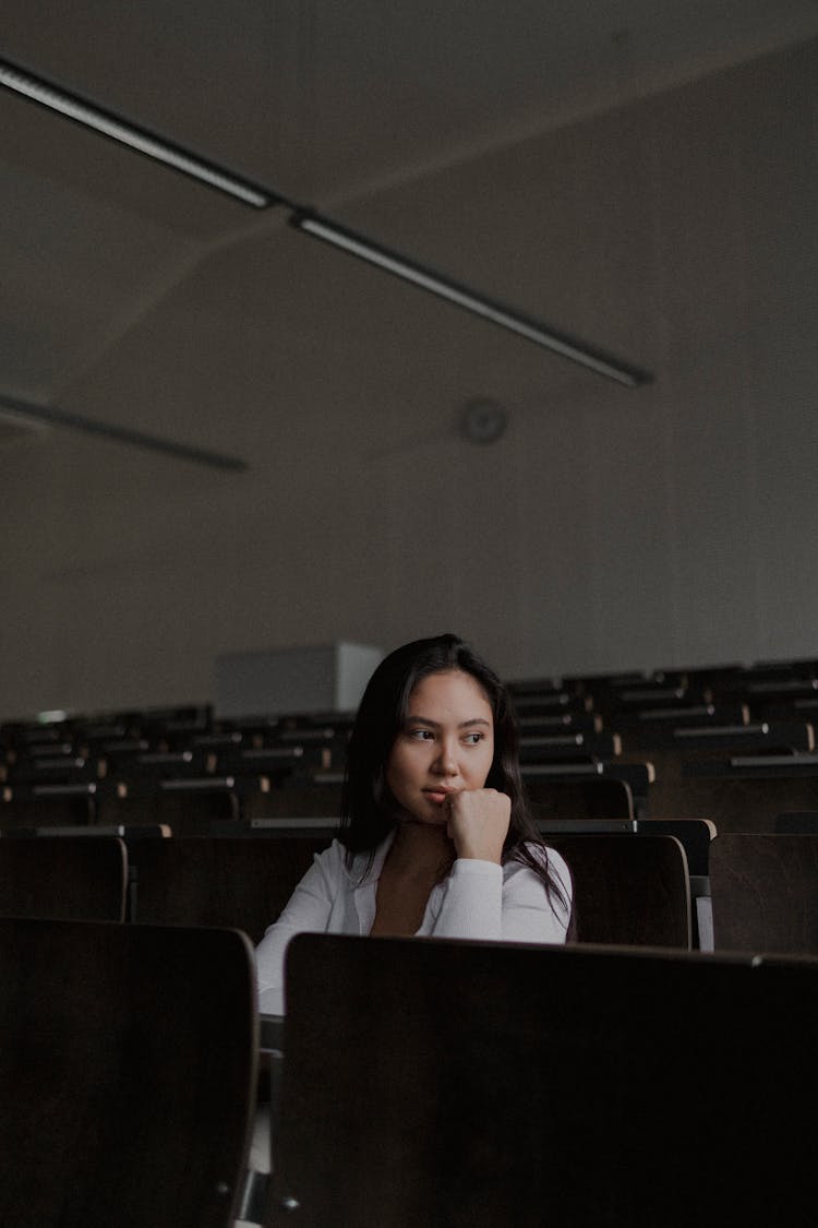 Woman Sitting Alone In An Auditorium Seat 