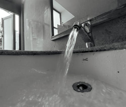 Black and White Shot of Water Running from a Tap 