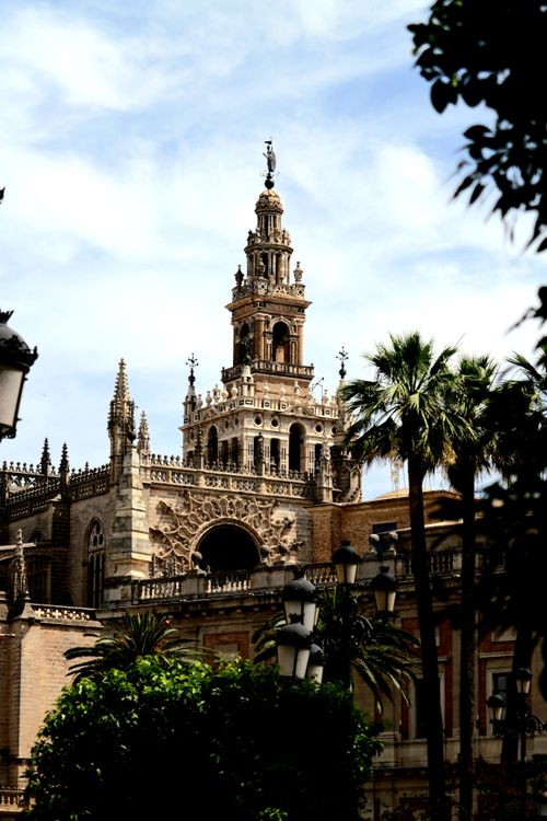 Free The iconic Giralda Tower in Seville stands tall against a bright blue sky, showcasing its Moorish architecture. Stock Photo