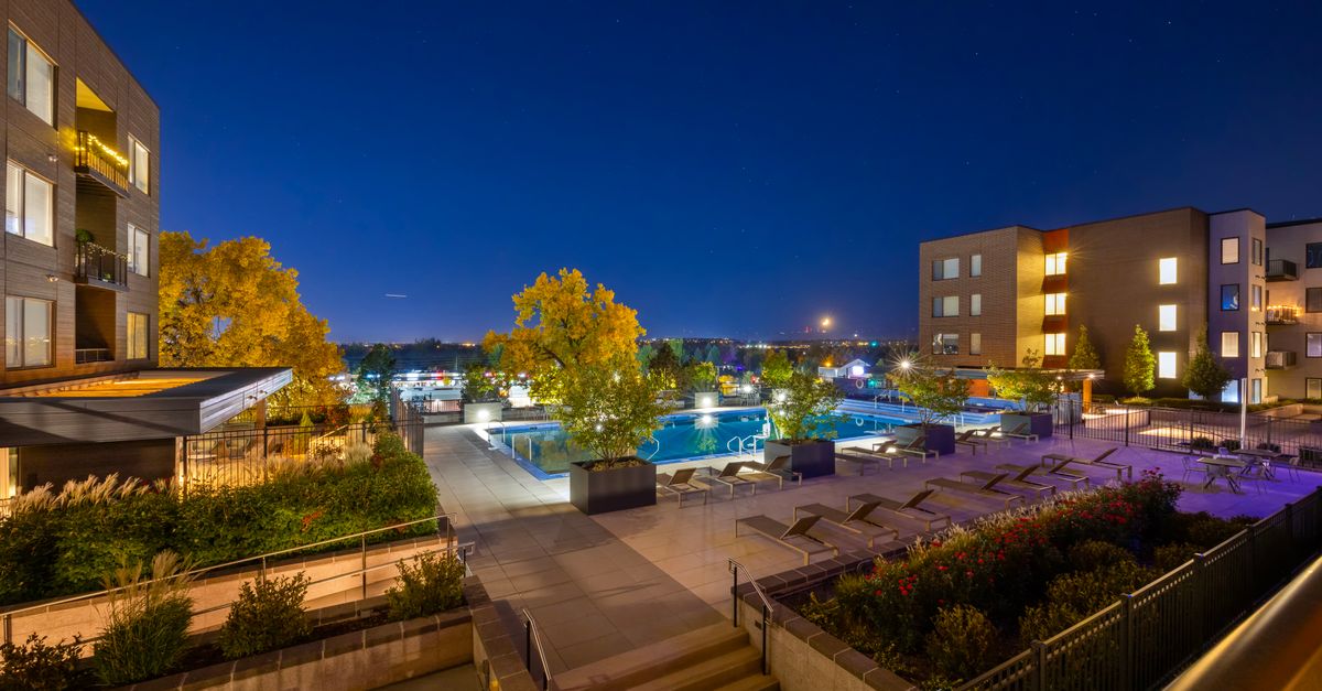 Night view of a luxurious apartment complex with a swimming pool in Westminster, Colorado, USA.