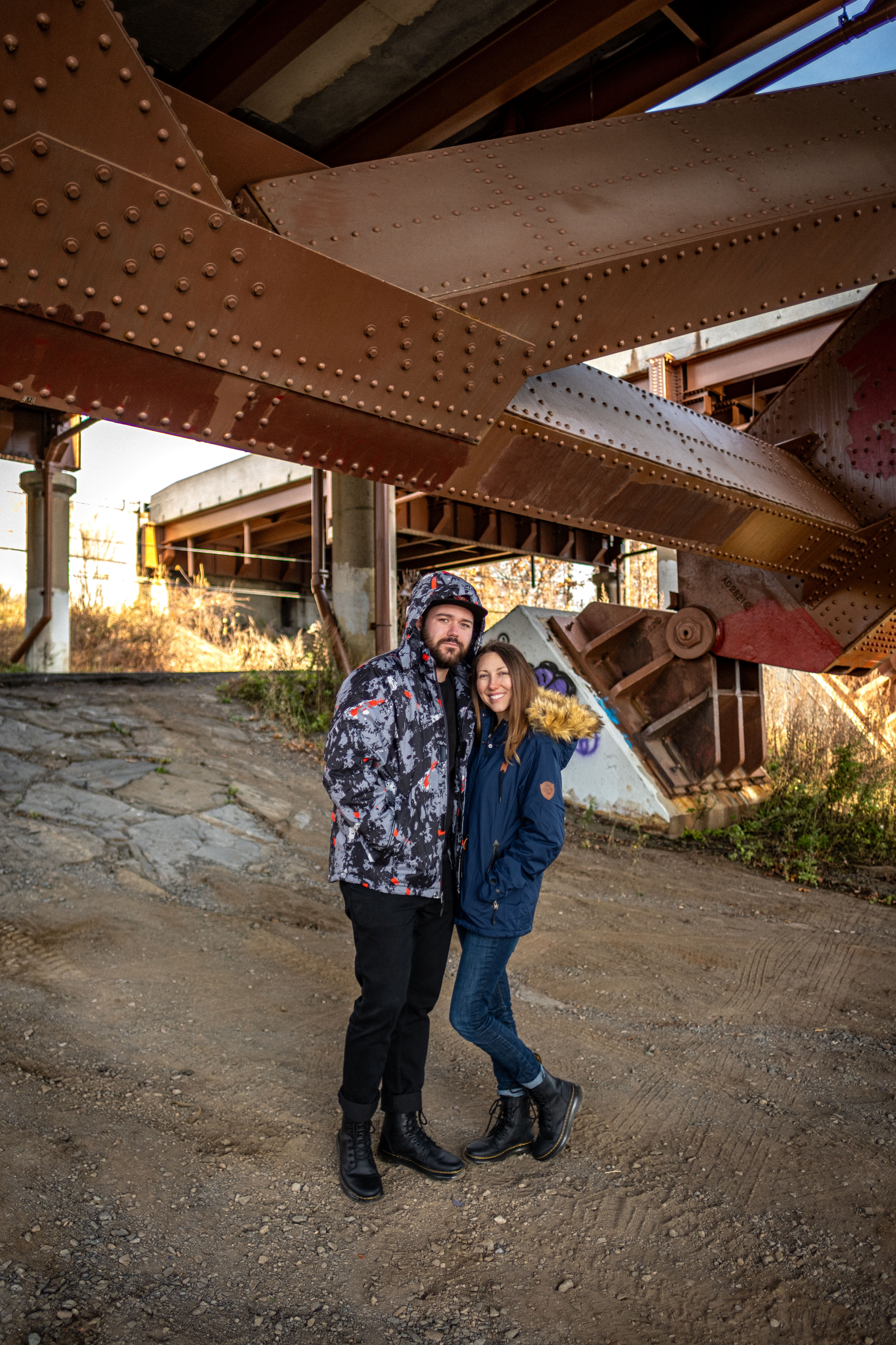 Casual Style Models in Jackets Posing under Bridge · Free Stock Photo