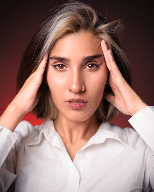 Free A woman with a headache is holding her head Stock Photo