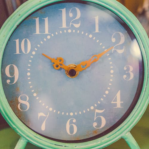 10:10 시간을 표시하는 둥근 청록색 및 흰색 아날로그 탁상 시계