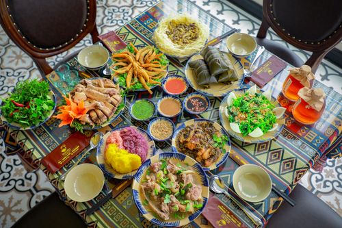 Free Rich traditional Vietnamese meal on a vibrant patterned tablecloth with various dishes. Stock Photo