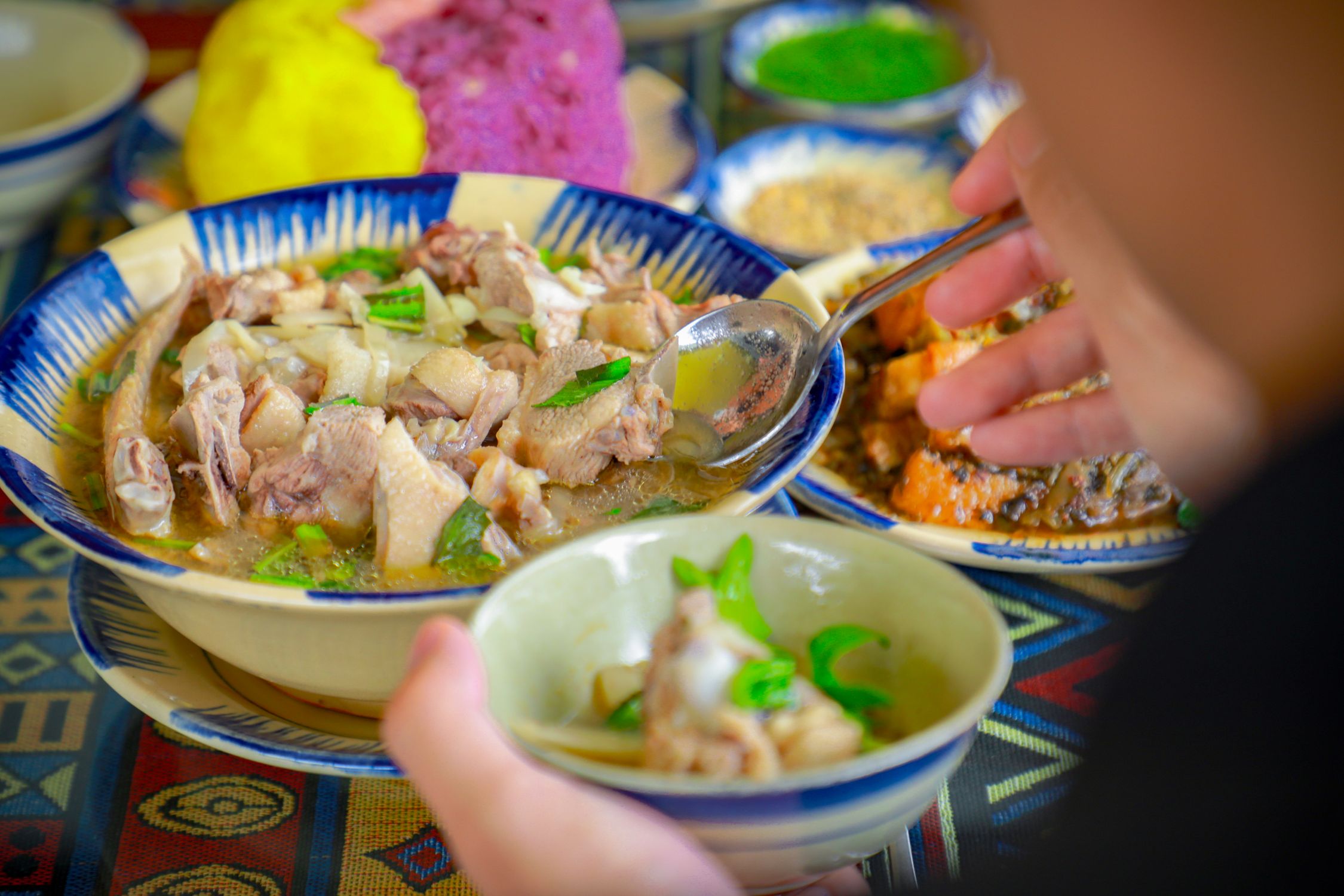 Close-up de uma sopa de frango nutritiva sendo servida em um jantar vibrante e saudável