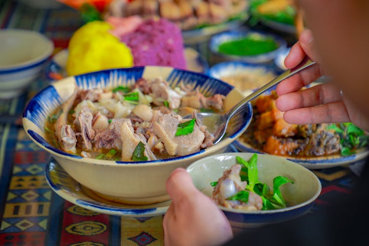 Person Eating Fish Soup