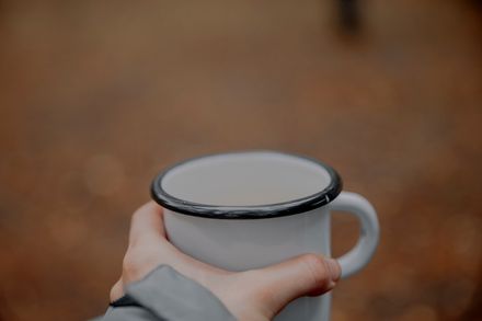 Close-up of an enamel mug held outdoors — Elina Volkova on Pexels