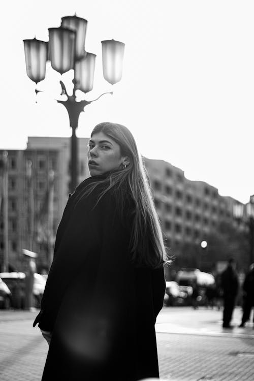 Young Woman in Black Coat Posing on Street