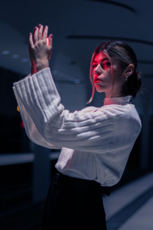 Free Portrait of a woman at night in Berlin with dramatic neon lighting. Stock Photo