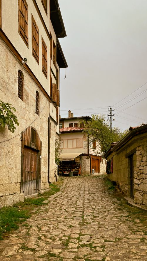 Free Quaint village scene with cobblestone path and traditional Turkish houses. Stock Photo