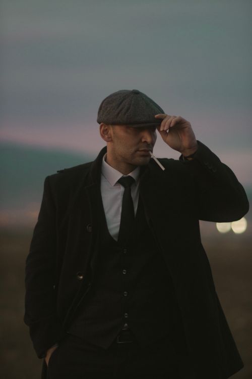 Free Stylish man in suit and hat smoking a cigarette at dusk. Stock Photo