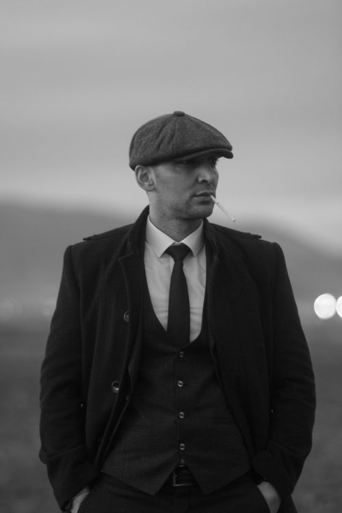 Free Black and white portrait of a stylish man in a suit and hat, smoking a cigarette. Stock Photo
