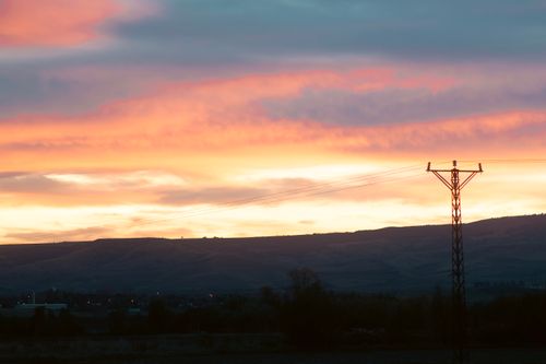 Free A beautiful sunset scene with transmission towers silhouetted against vibrant skies. Stock Photo