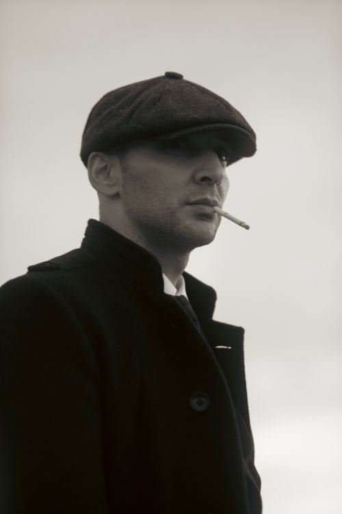 Free Portrait of a man in a hat smoking a cigarette, exuding vintage elegance. Stock Photo