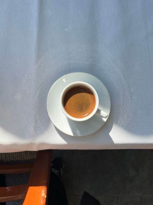 Free Aerial shot of a steaming cup of coffee on a well-lit table indoors. Stock Photo