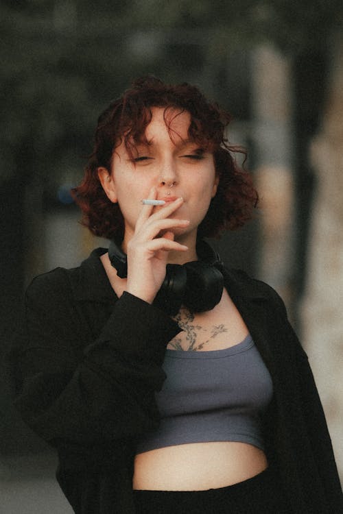 Young Woman in Black Shirt and Gray Crop Top Smoking a Cigarette