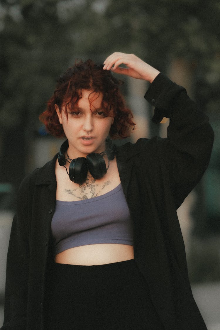 Young Woman With Headphones Standing Outside 