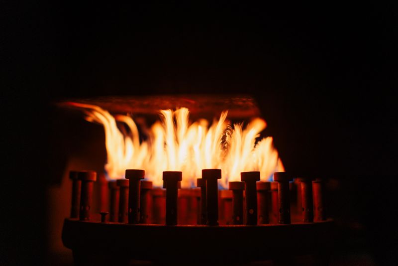Captivating image of bright orange flames dancing on a gas burner against a dark background, creating a dramatic ambiance.
