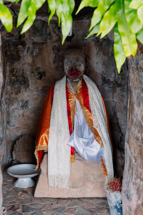 Stone Statue Dressed in Orange Cloak and White Scarf