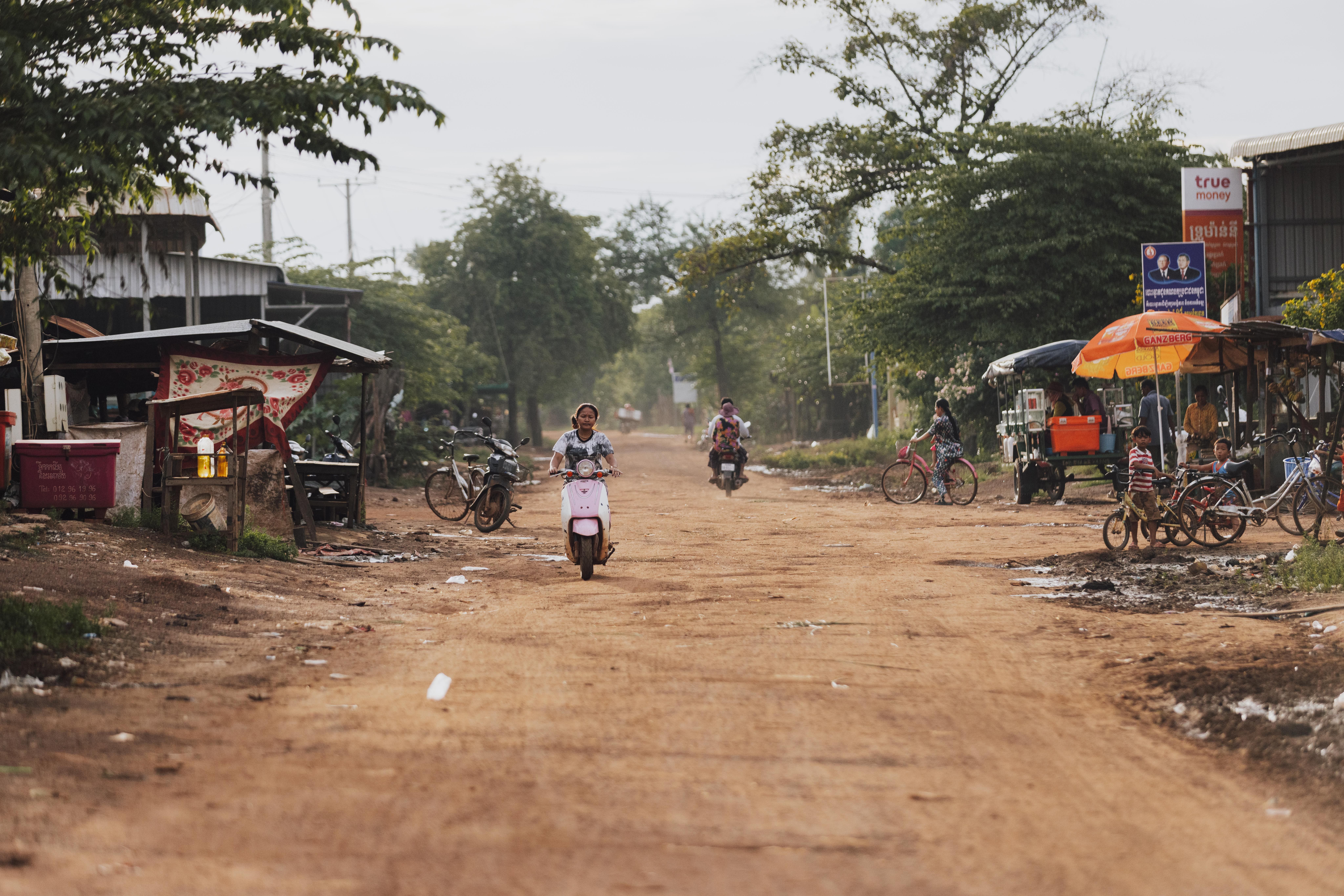 People Riding on Motor Scooters on an Unpaved Road in a Village · Free ...