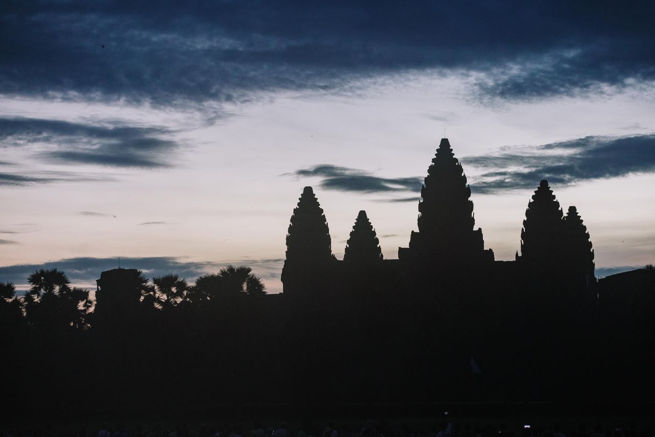 silhouette of angkor wat temple at dusk with dramatic sky