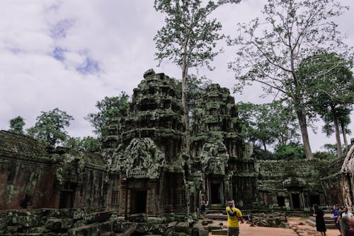Tourists Standing in a Yard of Ta Prohm Temple in Cambodia