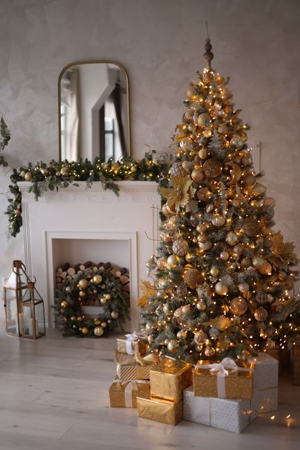 Warm and festive living room with a beautifully decorated Christmas tree and gifts by the fireplace.