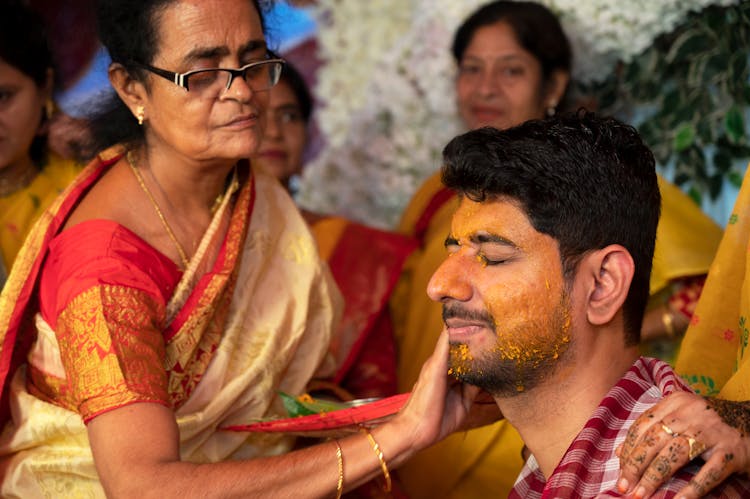 Woman In Traditional Clothing Putting Cream On Man Face For Ceremony