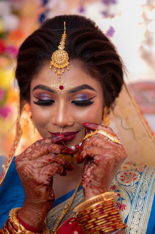 Free Stunning portrait of an Indian bride with henna tattoos, traditional jewelry, and closed eyes. Stock Photo