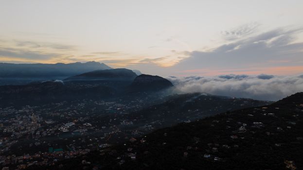 Stunning aerial view of Sorrento, Campania during twilight with rolling hills and clouds.