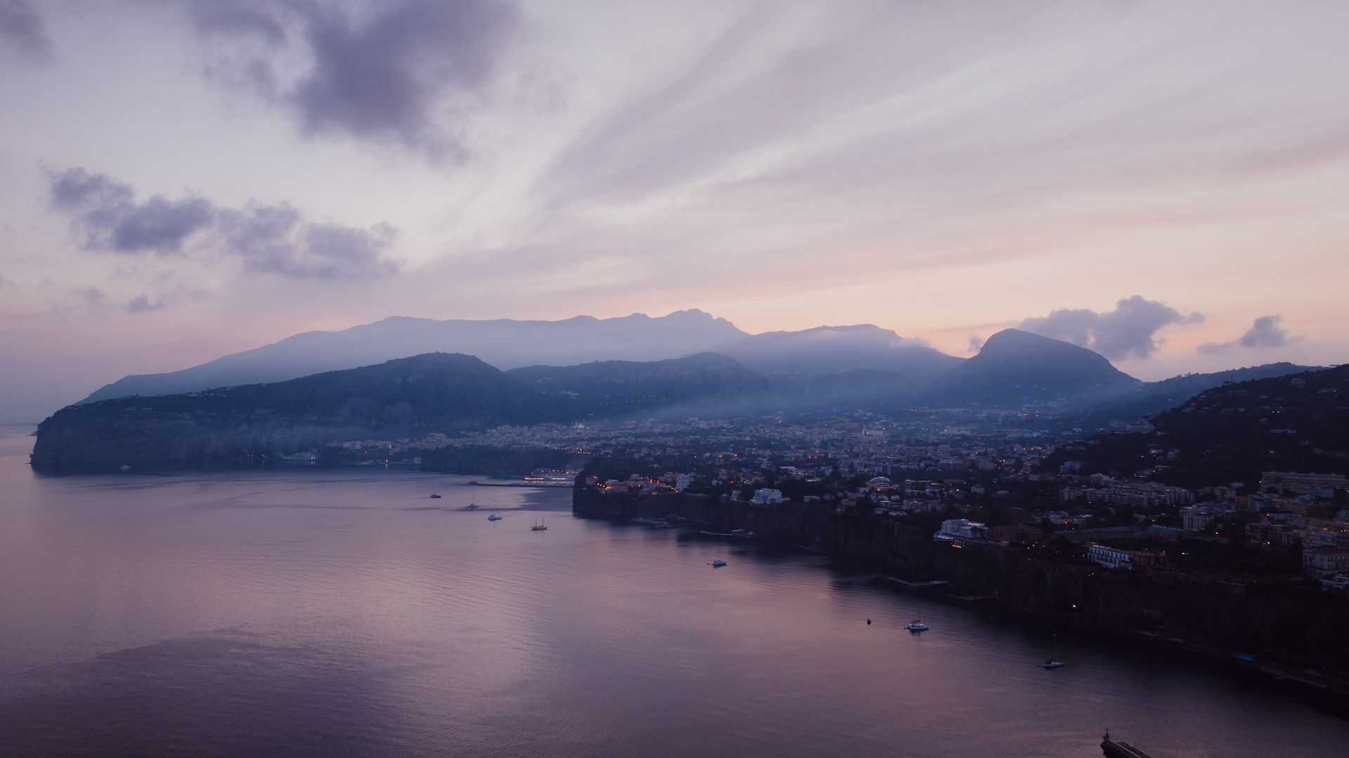 Captivating aerial view of Sorrento, Italy, with coastal landscape at twilight. Perfect blend of natural beauty and urban charm.