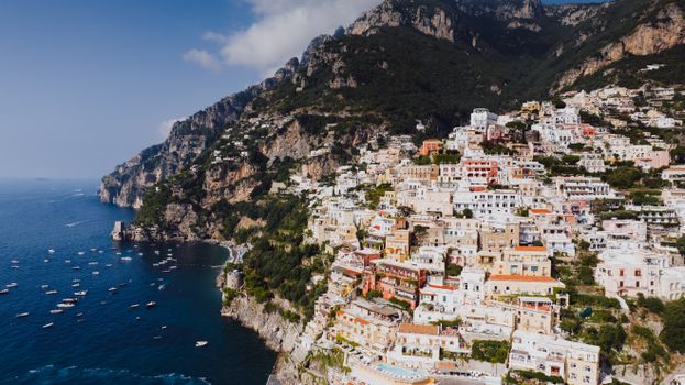 Explore the stunning coastline and colorful buildings of Positano, Italy from above.