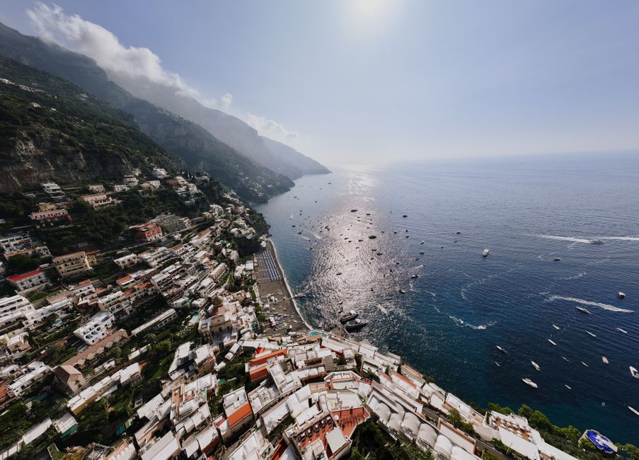 Stunning aerial view of Positano's coastline under sunlight, highlighting its picturesque beauty.