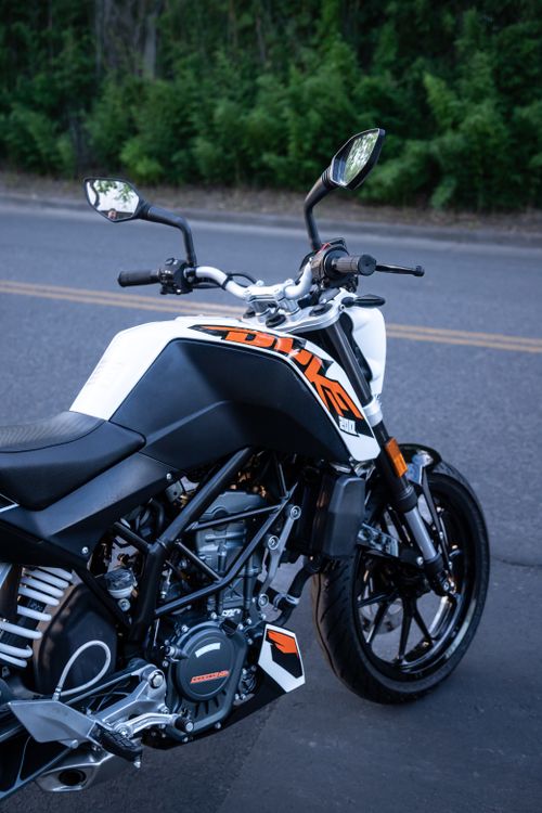 Free Close-up of a sleek modern motorcycle parked on a quiet city street. Stock Photo
