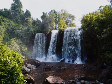 Beautiful waterfall in Cambodian jungle with lush greenery, perfect for adventure and nature enthusiasts.