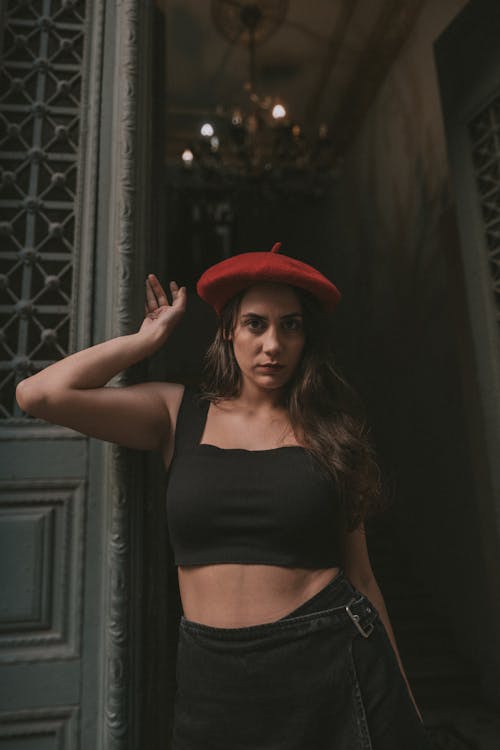 Model in a Red Beret and a Black Crop Top Standing in the Doorway of an Old Building