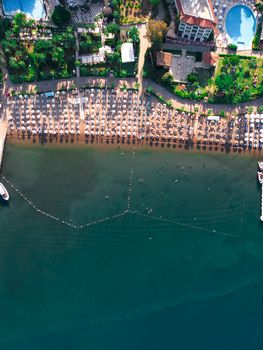 Aerial snapshot of a busy beach resort with sun loungers and umbrellas.