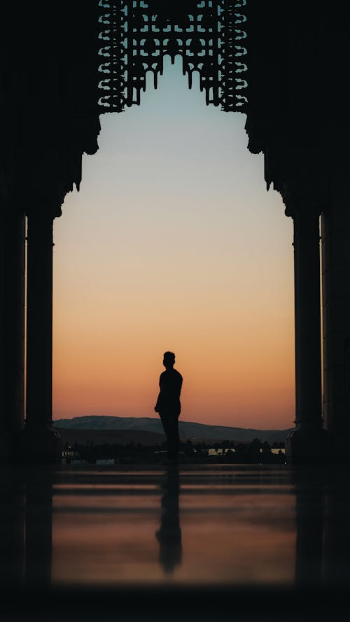 Silhouette of a Man and an Ornate Mosque Window 