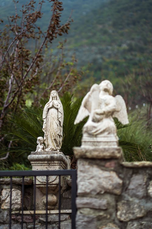 Free Statues of Angel and Virgin Mary on Stone Wall Stock Photo