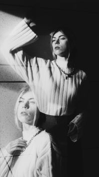 Double exposure portrait of a woman showcasing artistic motion and shadow play in black and white.