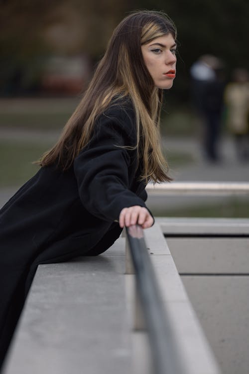 Woman in Black Clothes Leaning on Railing