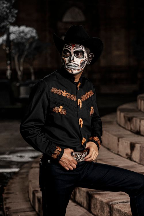 Free Portrait of a man in Day of the Dead attire with intricate face paint and traditional clothing. Stock Photo