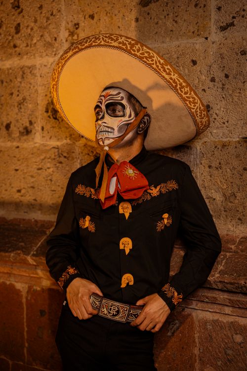 Free Man in traditional Mexican attire with skull makeup, symbolizing Day of the Dead celebration. Stock Photo