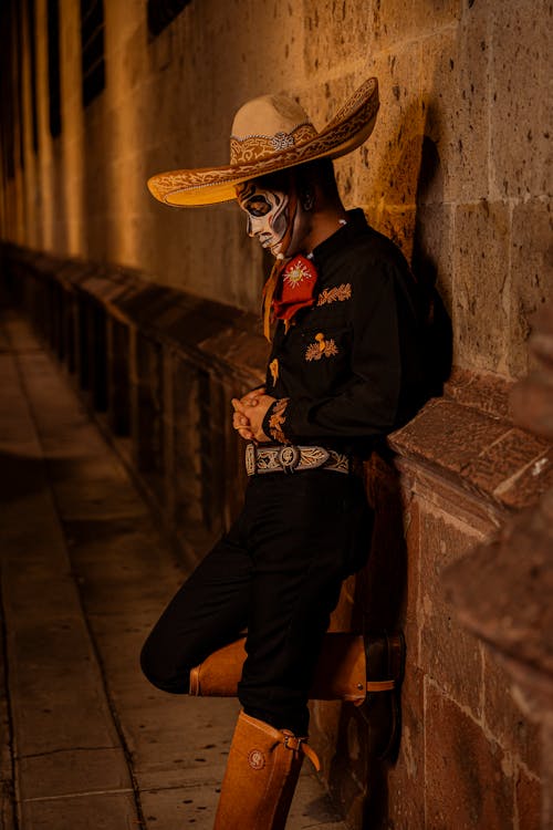 Man in Traditional Clothing and Sombrero at Night